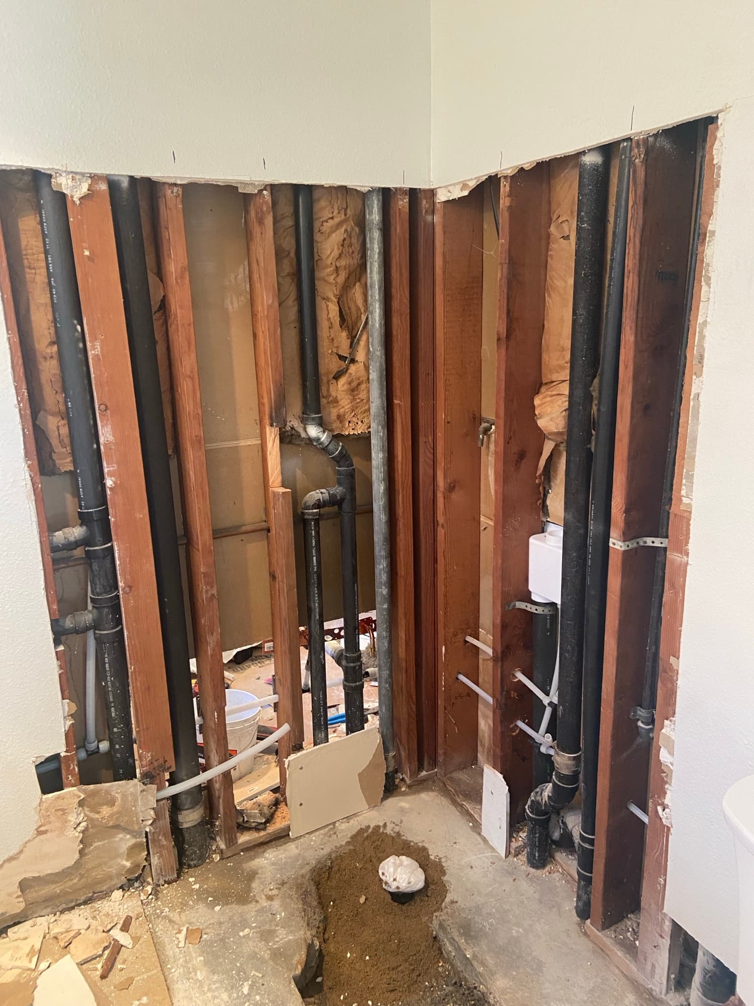 Black ABS drain pipes routed through ceiling joists during an Orange County plumbing repair