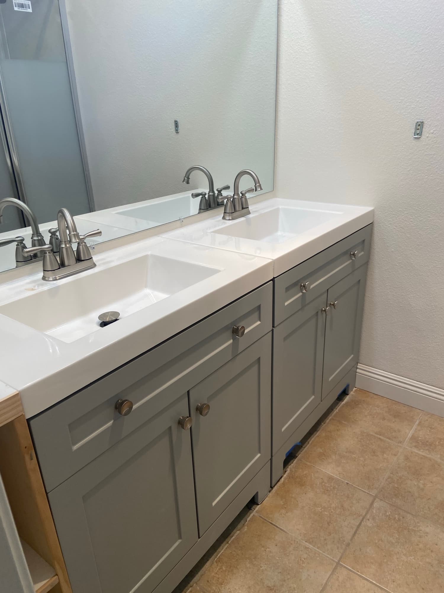 Double bathroom vanity with matching brushed nickel faucets installed side by side, Orange County, CA
