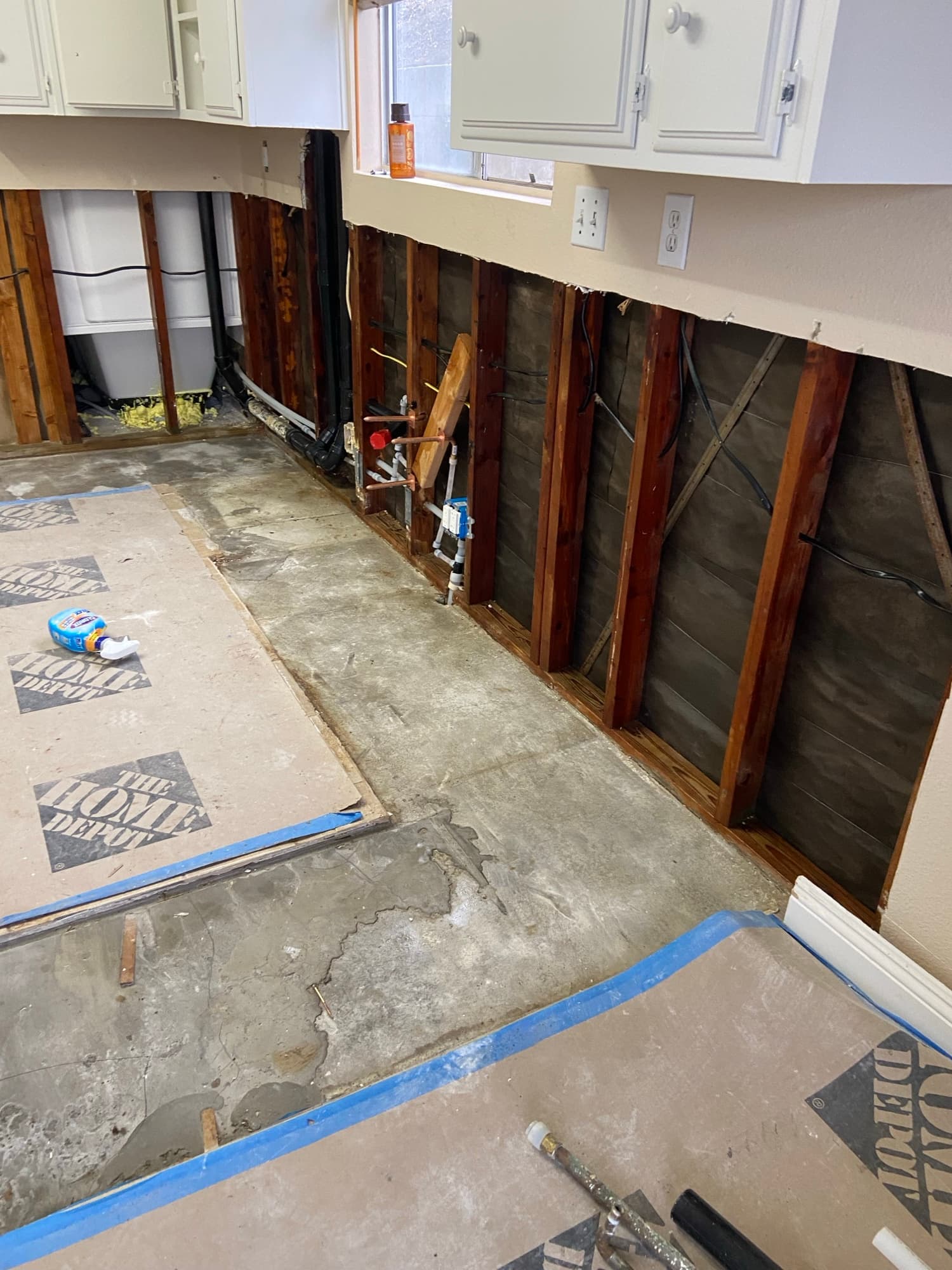 Kitchen ceiling framing exposed with plumbing pipes routed above the cabinets, Orange County, CA