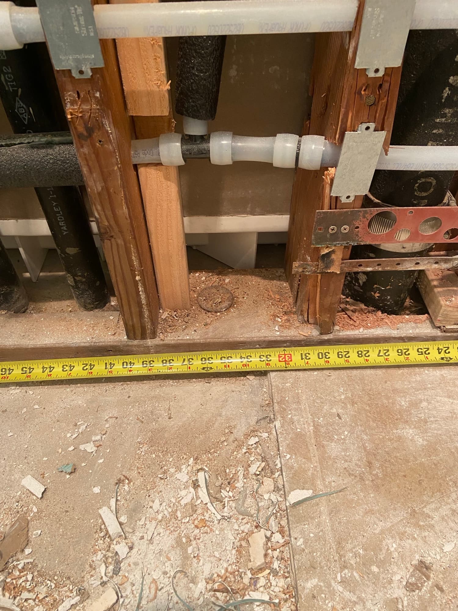 Close-up of PEX pipe fittings inside an open wall cavity, Orange County, CA