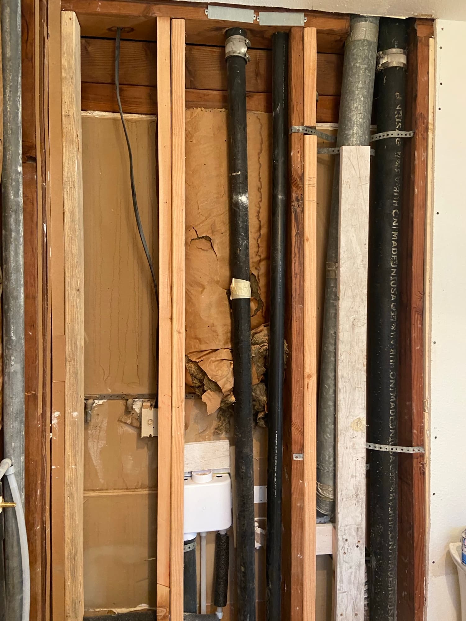 Stamped Schedule 40 ABS pipe secured to wood framing with metal strapping, Orange County, CA