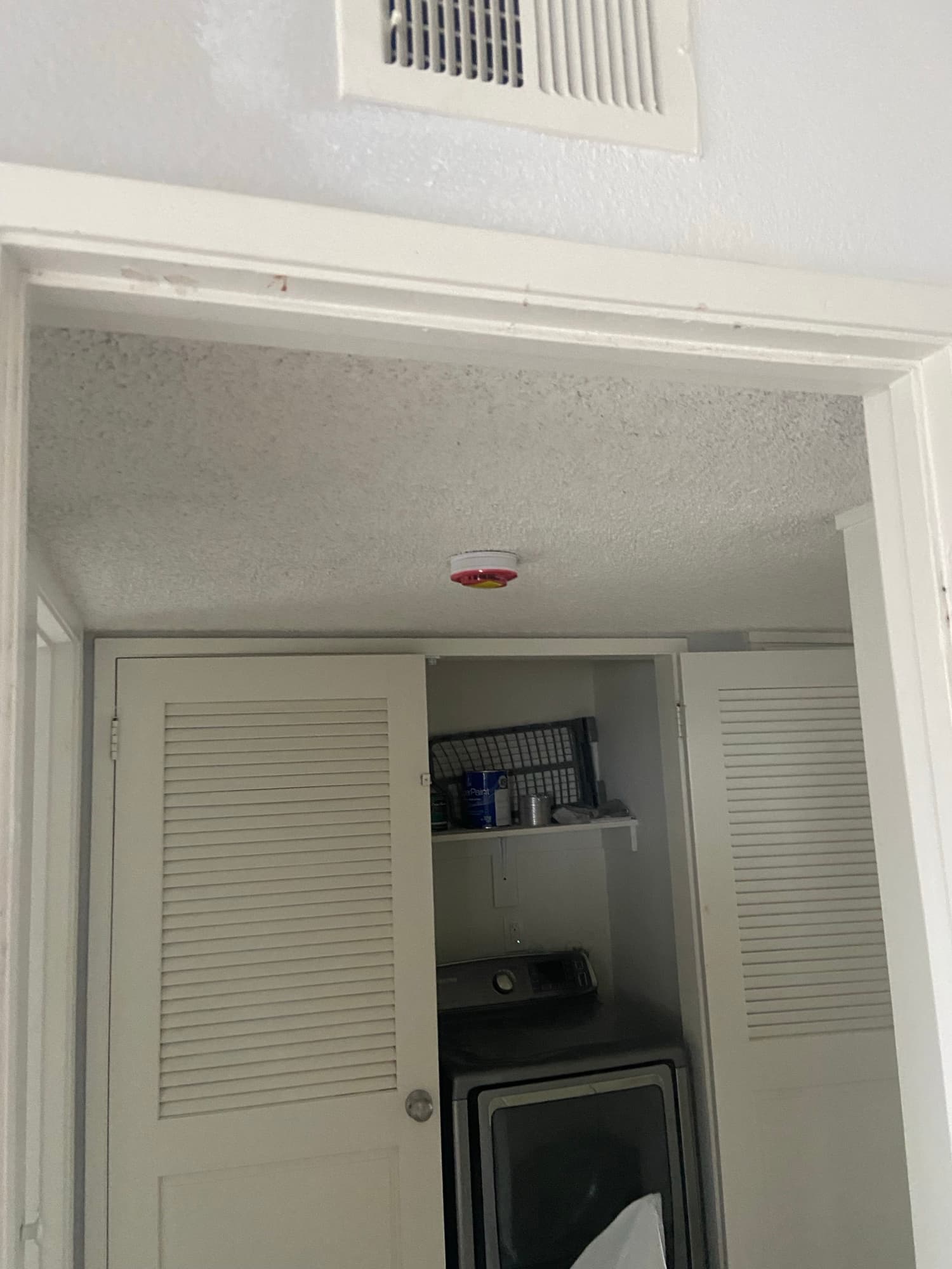 Louvered utility closet with ventilation grilles and a smoke detector, Orange County, CA