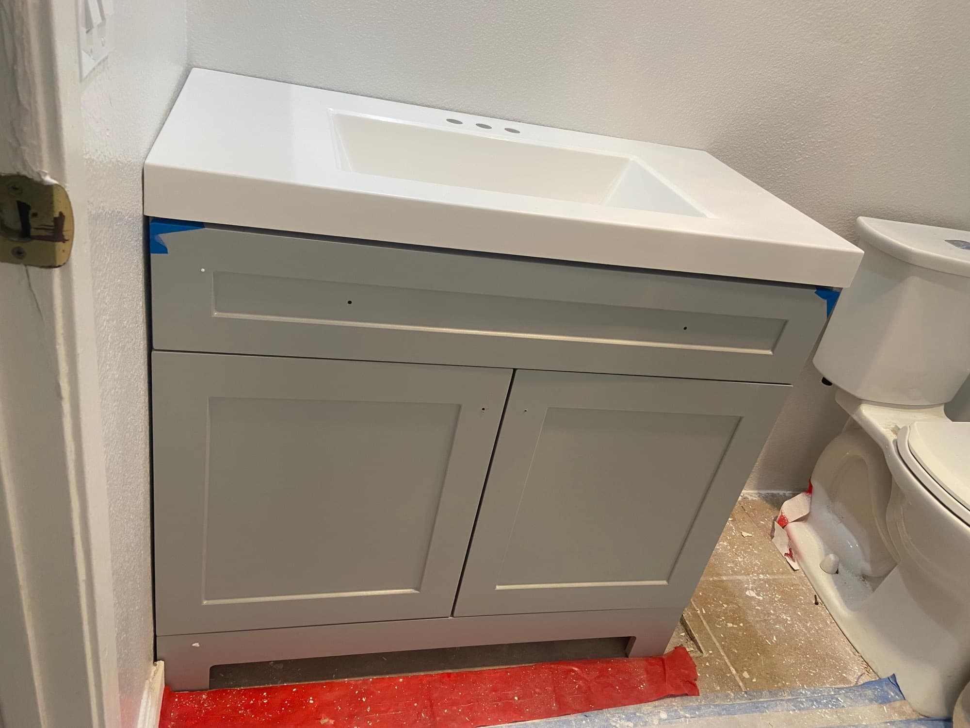 New vanity protected with tape near a toilet during a bathroom remodel, Orange County, CA