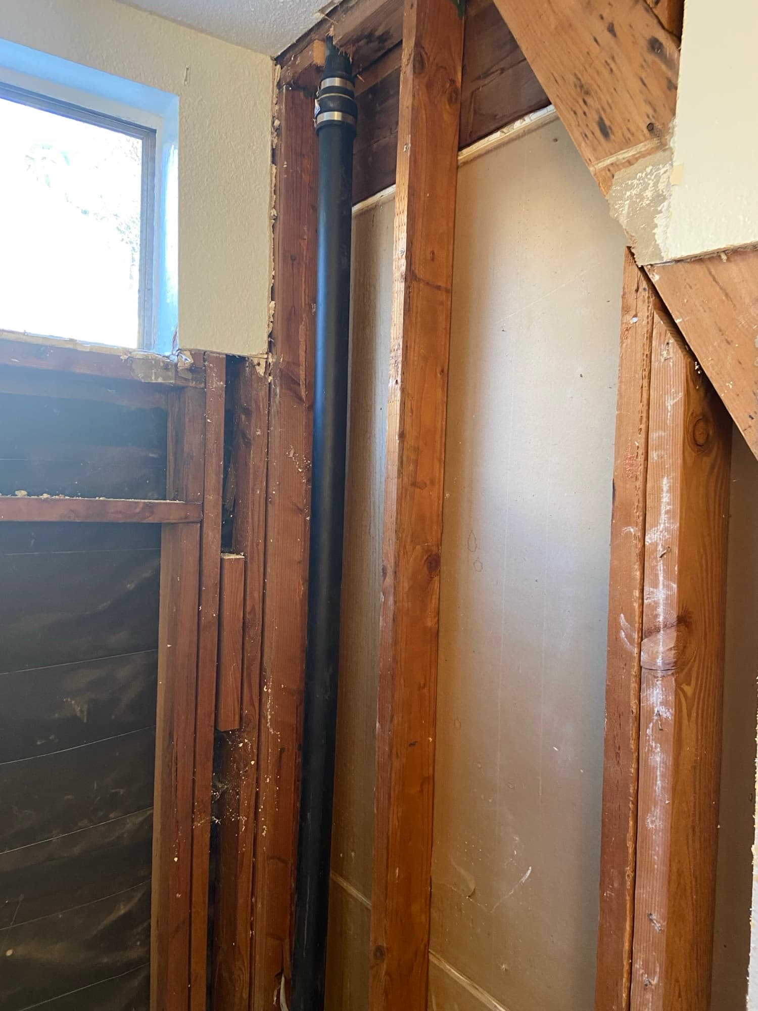 Plumbing vent pipe routed through ceiling joists above fresh insulation, Orange County, CA